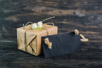 gift box and cardboard with copy space on dark wooden background