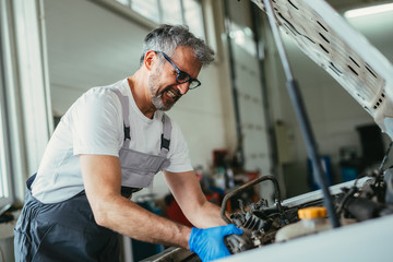 Fototapeta na wymiar worker repairing car engine in car service