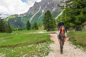 Fototapeta na wymiar Mum with small child in a backpack walks along dolomites, Italy.