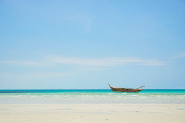 Fototapeta na wymiar canoe on the beach with blue sky