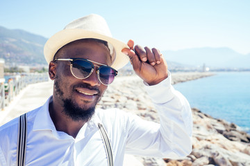 handsome african american person casual fashion look outfit in straw hat,white shirt walking by...