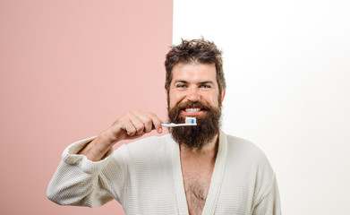 Smiling bearded man brushing teeth. Tooth brush. Tooth paste. Morning treatments. Morning routine. Health care. Dental hygiene.