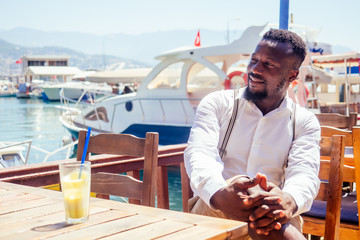 handsome african american business man with healthy smoothie in summer beach tropical cafe in Turkey