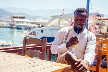 handsome african american business man with healthy smoothie in summer beach tropical cafe in Turkey