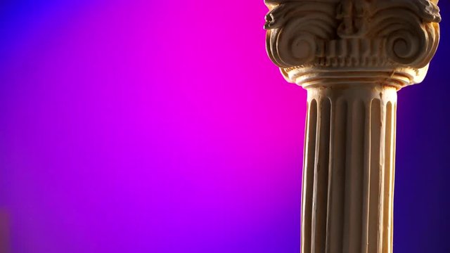 Single ancient corinthian column rotating slowly on color background