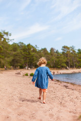 Mädchen spaziert am Strand. Little girl walking at the beach.