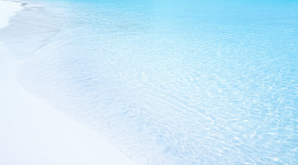 Transparent sea water hitting a white sandy beach