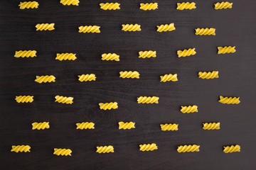 Pattern of A pile of pasta spiral fusilli on black background
