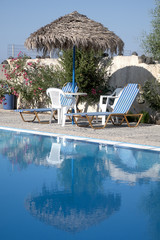 Sunbeds, Umbrella and table at the board of a idyllic swimming pool