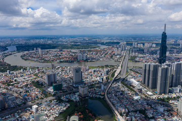 Obraz premium Top View of Building in a City - Aerial view Skyscrapers flying by drone of Ho Chi Mi City with development buildings, transportation, energy power 