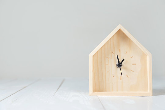 Wooden table clock in the shape of a house.