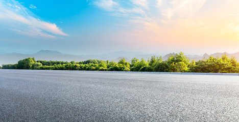 Asphalt highway and green forest with beautiful cloud landscape at sunset