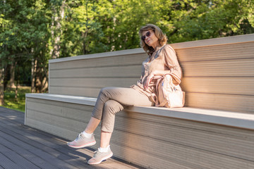 A woman is resting on a park bench.