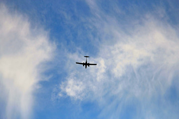 Light aircraft landing on a cloudy sky