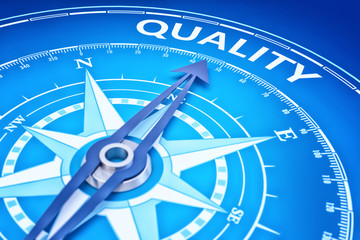 Quality as business strategy concept and marketing goal of management productivity, blue background with a compass pointing to the target