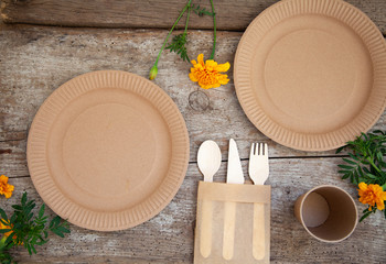 ecological disposable tableware paper cardboard empty on a wooden table with yellow flowers