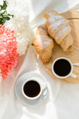 Two black coffee and croissants on a white bed. Breakfast concept