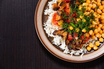 Rice with chickpea and vegetables on wooden table