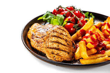 Grilled chicken fillet with french fries on white background