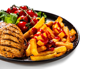 Grilled chicken fillet with french fries on white background
