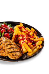 Grilled chicken fillet with french fries on white background