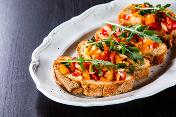 Bruschettas on plate on wooden background