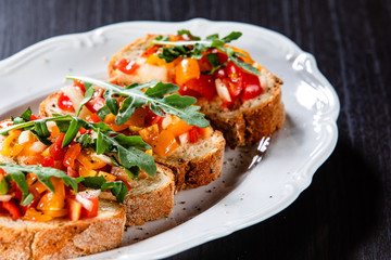 Bruschettas on plate on wooden background