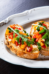 Bruschettas on plate on wooden background