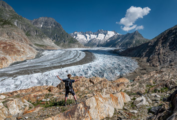Fototapeta premium hiker enjoys view over the mighty Aletsch Glacier in Switzerland
