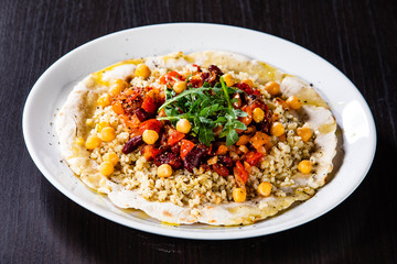 Groats with sauce and vegetables on tortilla