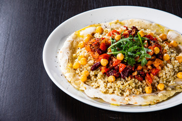 Groats with sauce and vegetables on tortilla