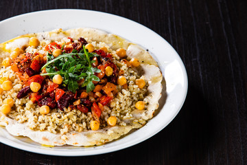 Groats with sauce and vegetables on tortilla