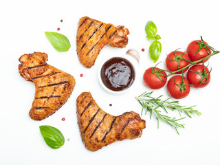 grilled chicken wings, brown bbq sauce tomatoes basil rosemary spices on white background