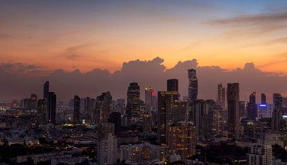 Panorama of cityscape with sunset over the building and blue sky at bangkok ,Thailand. View of the tall building in capital with twilight .Shot using Panorama technique.