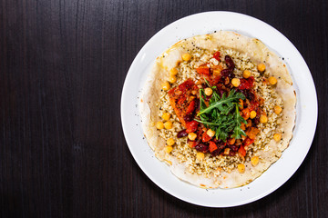 Groats with sauce and vegetables on tortilla