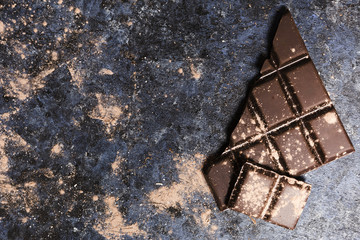 Flat lay chocolate covered in cocoa on grunge table