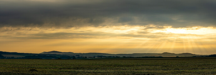 Scenic view on rural landscape in golden morning sunrise with sun rays breaking through the clouds. Upper Lusatia Bernstadt Germany