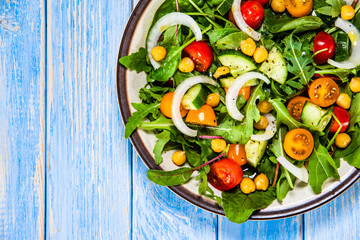 Greek salad with chickpea on wooden background