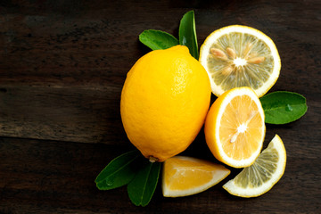 fresh lemon with leaves and ripe on wood background
