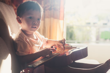 young boy playing guitar	