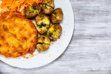 Fried pork chop, boiled potatoes and vegetable salad