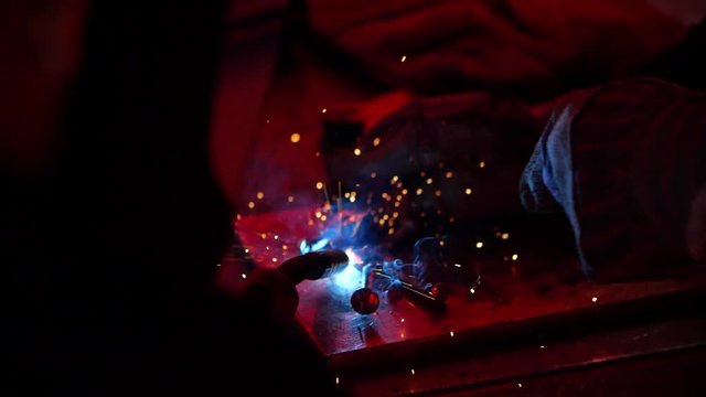 A slow mo close up shot of apprentice learning the ropes on a construction site, futuristic industrial practice sparks flying around quick fix on this job career