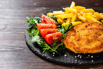 Fried pork chop, French fries and vegetables