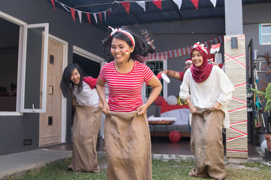 portrait of young asian people compete sack race during indonesia independence day