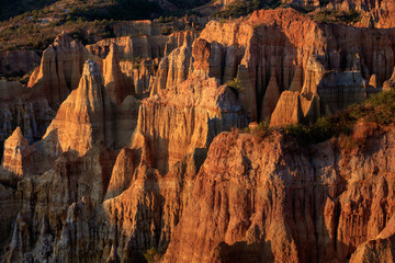 Earth Forest of Yuanmou in Yunnan Province, China - Exotic earth and sandstone formations glowing in the sunlight. Naturally formed pillars of rock and clay with unique erosion patterns. China Travel