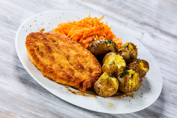 Fried pork chop, boiled potatoes and vegetable salad