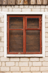The window of an old brick shed with a frame of red