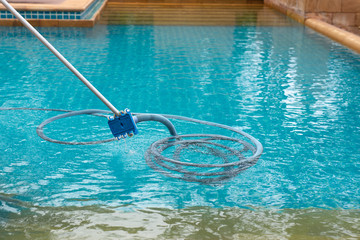 Pool vacuum cleaning dirty in bottom of swimming pool.