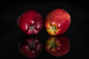 Fototapeta na wymiar Group of two whole fresh apple red delicious isolated on black glass
