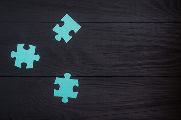 Puzzles on a black wooden background.